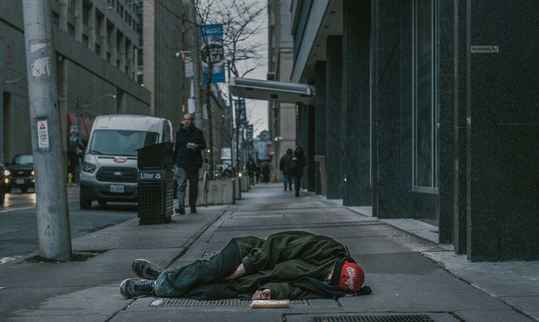 photo of man laying on sidewalk