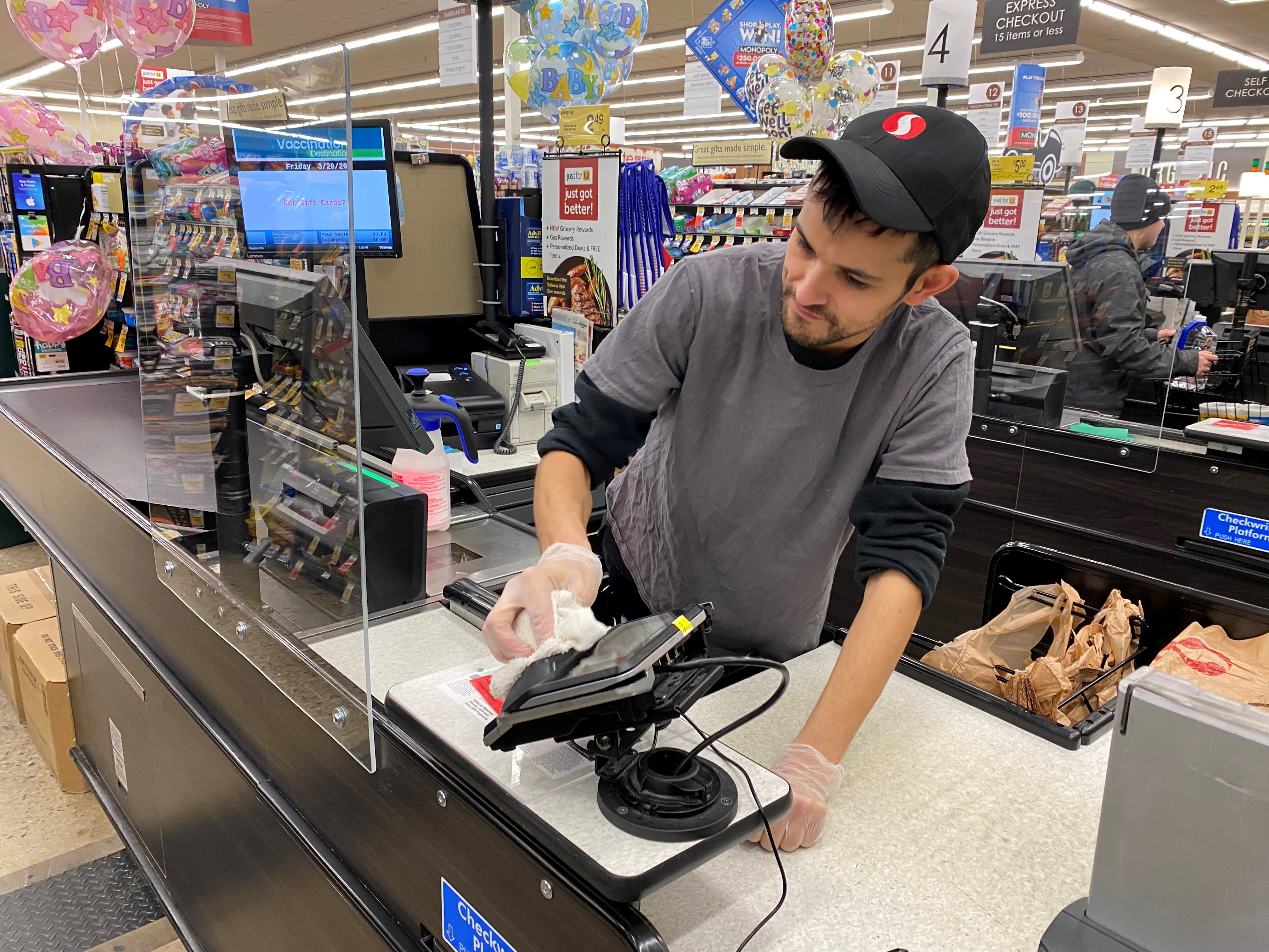 Safeway employee cleaning checkstand