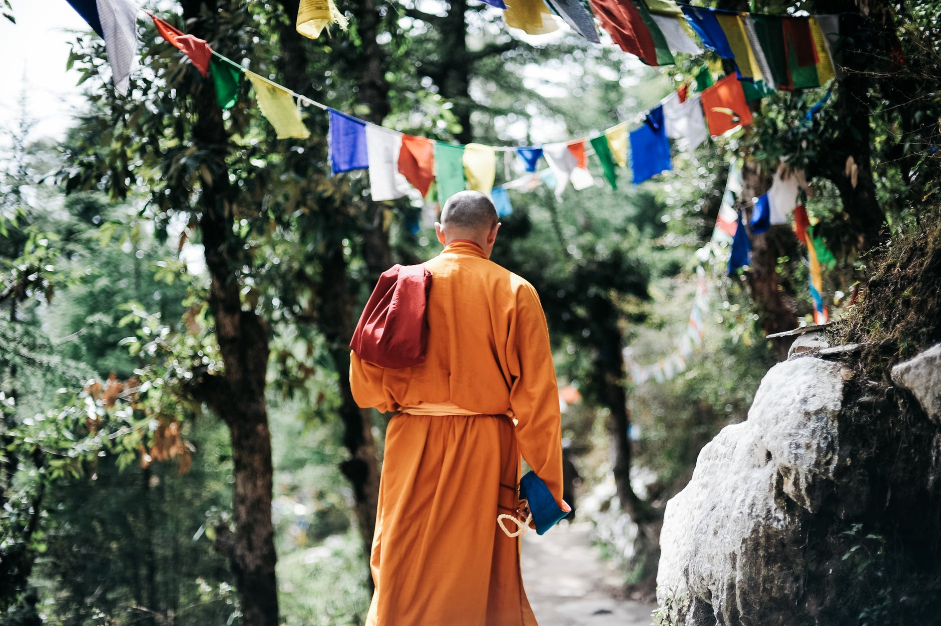 monk walking near buntings during day